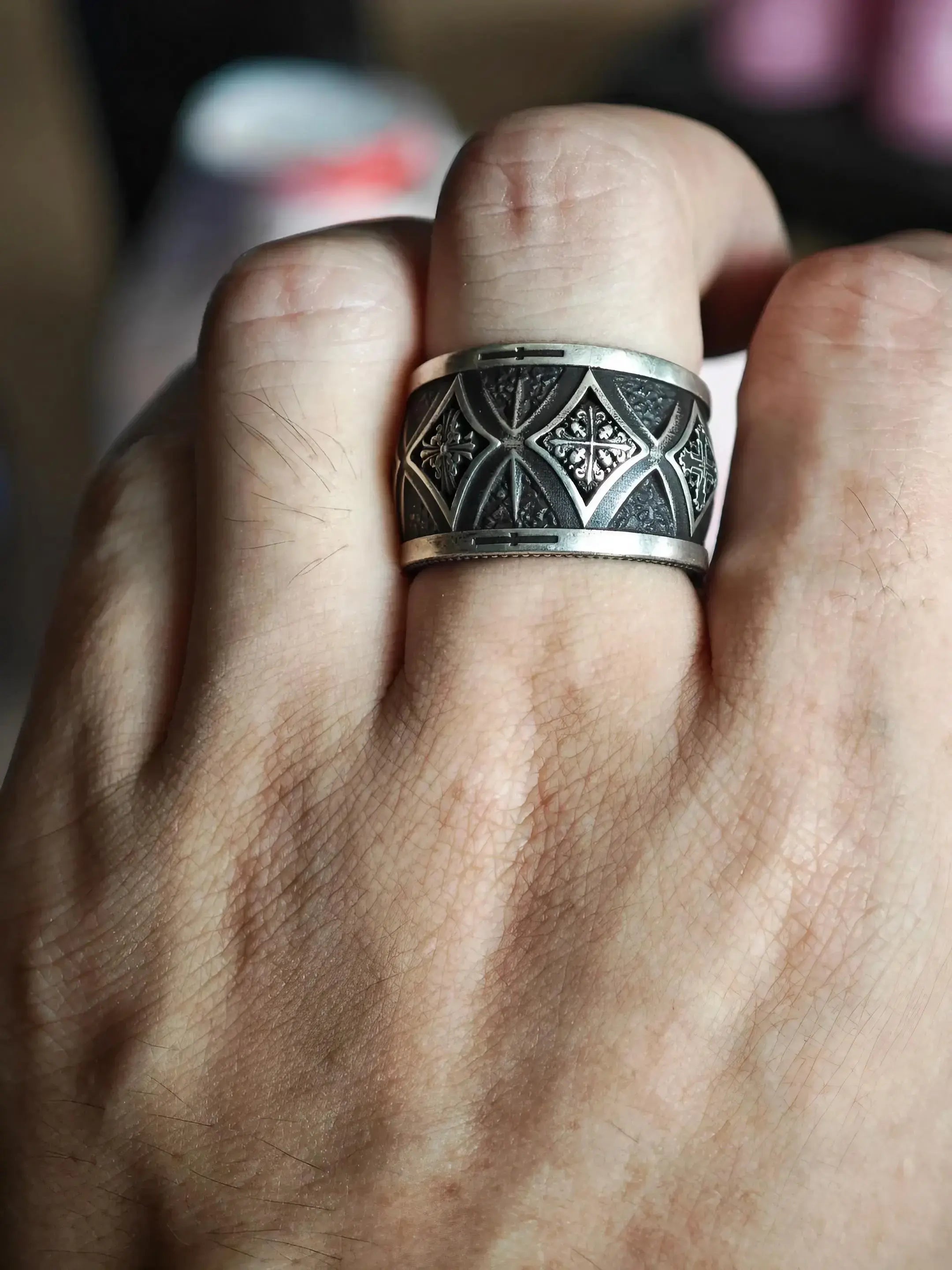 Hand wearing gothic cross wide band ring — alternative wedding band in solid 925 sterling silver