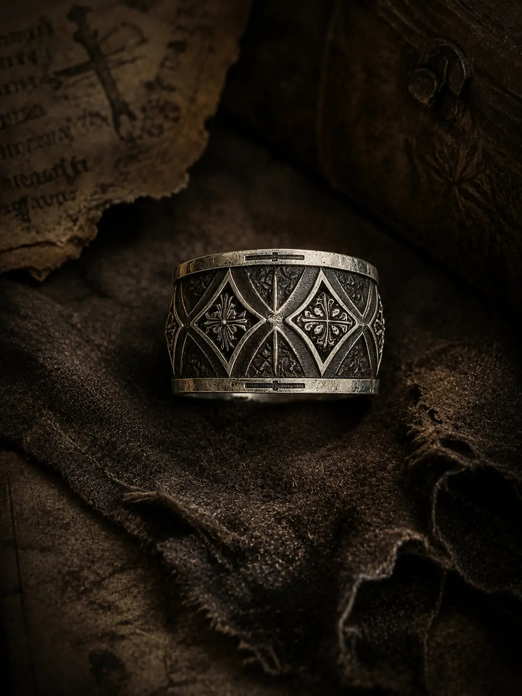 Gothic cross armor band close-up — interlocking pointed arches and deeply recessed cross motif in sterling silver