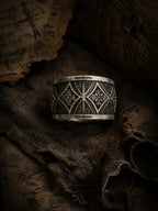 Gothic cross armor band close-up — interlocking pointed arches and deeply recessed cross motif in sterling silver