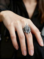 Hand wearing gothic cathedral facade ring — alternative wedding ring with tiara-like crown silhouette
