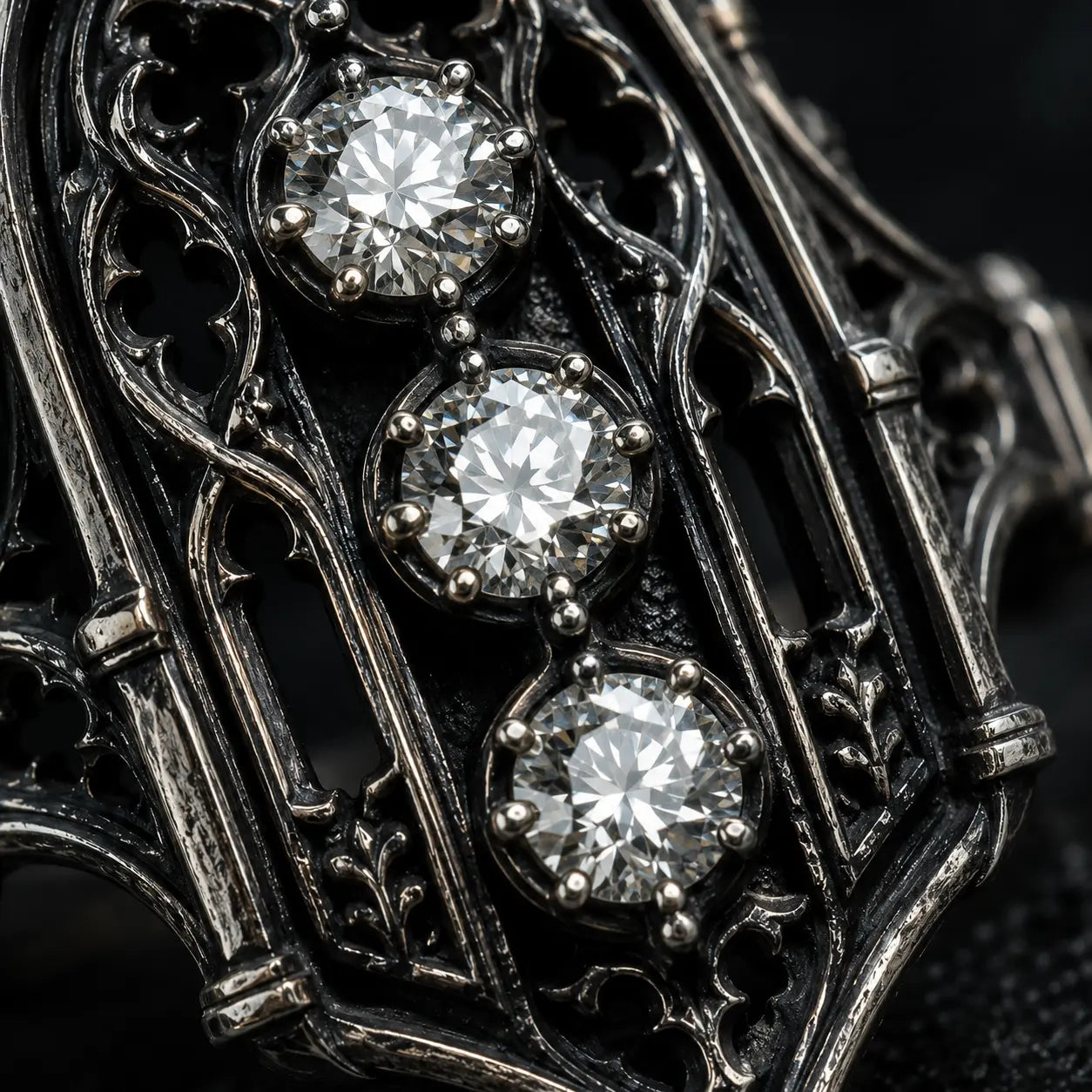 Close-up of an ornate metal object with three diamonds embedded in it. moissanite, Victorian, oxidized silver