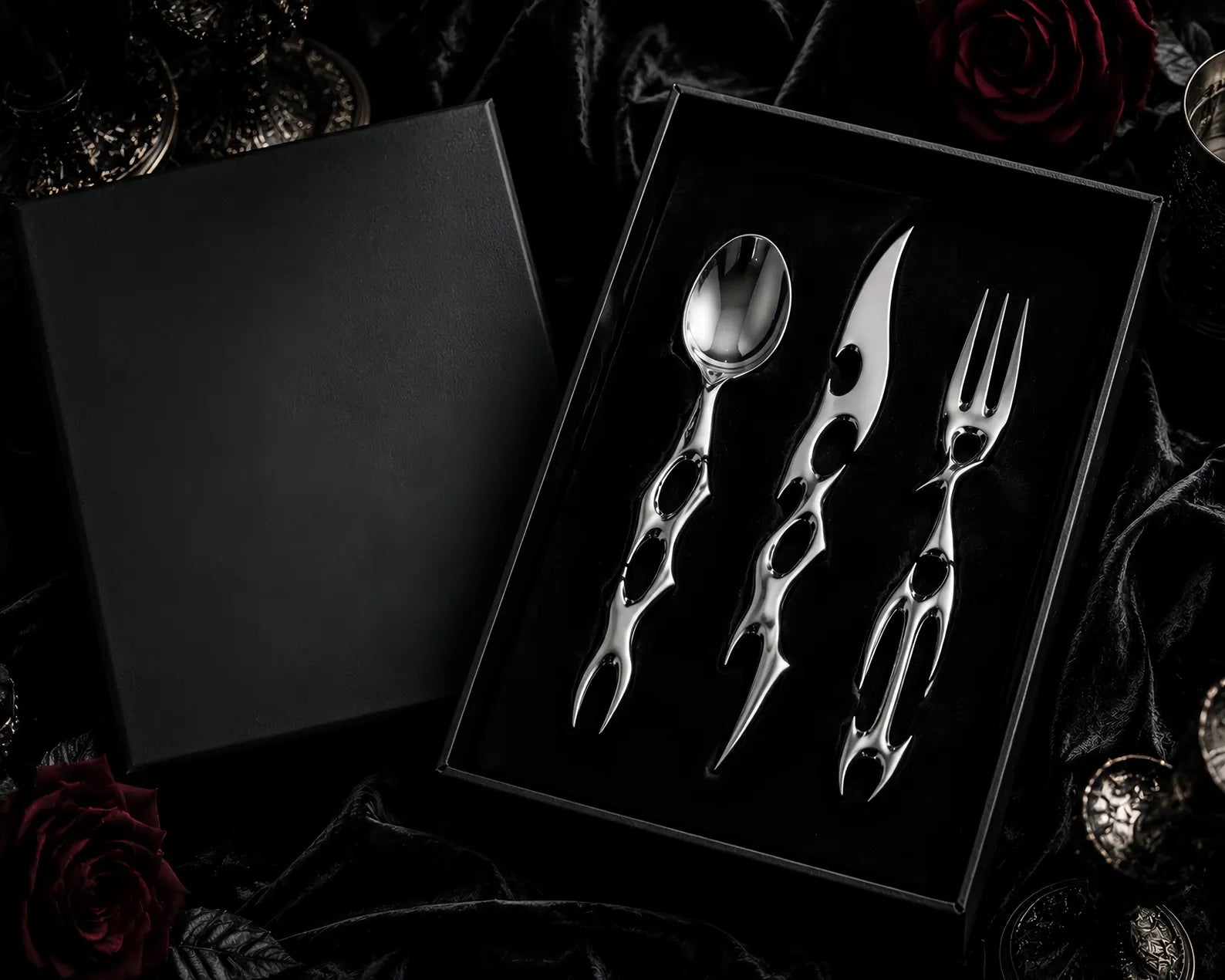 Cyber Baroque cutlery set presented in a black gift box on dark roses — luxury gothic tableware gift